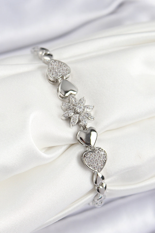 BB7528 - Pirinç Zirkon Taşlı Kalp Detaylı Çiçek Model Gümüş Renk Kadın Bileklik